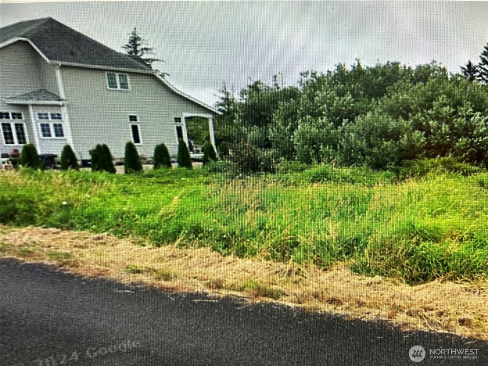 258 Stringtown Road Ilwaco, WA 98624 - Photo 4 of 8 a white house that has a tree in front of it