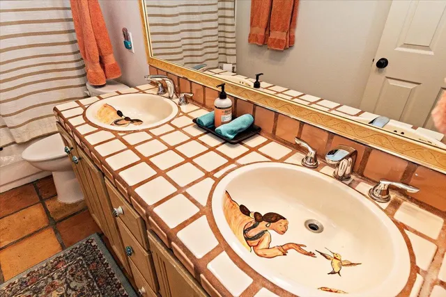 a bathroom with a sink and mirror with bathtub