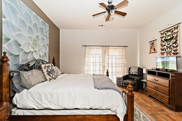 a bedroom with a bed and dresser with wooden floor