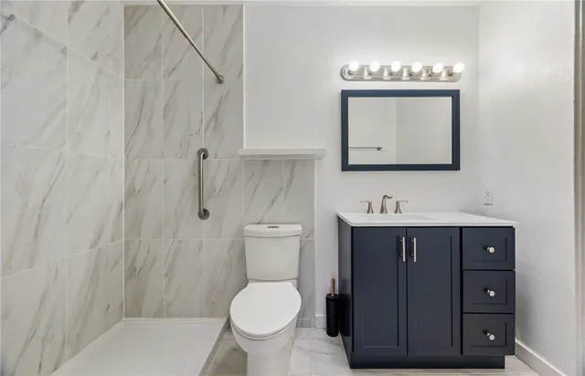 a bathroom with a toilet a sink a vanity and mirror