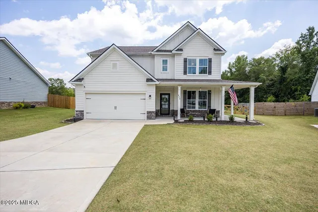 a view of a house with a backyard and a tree