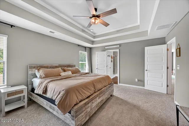 a spacious bedroom with a bed a chandelier