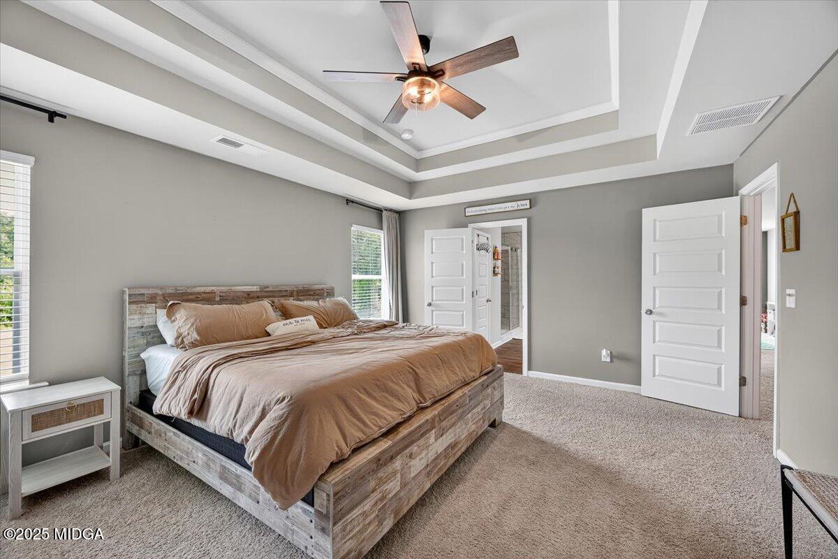 656 Dolly Drive Forsyth, GA 31029 - Photo 16 of 30 a spacious bedroom with a bed a chandelier