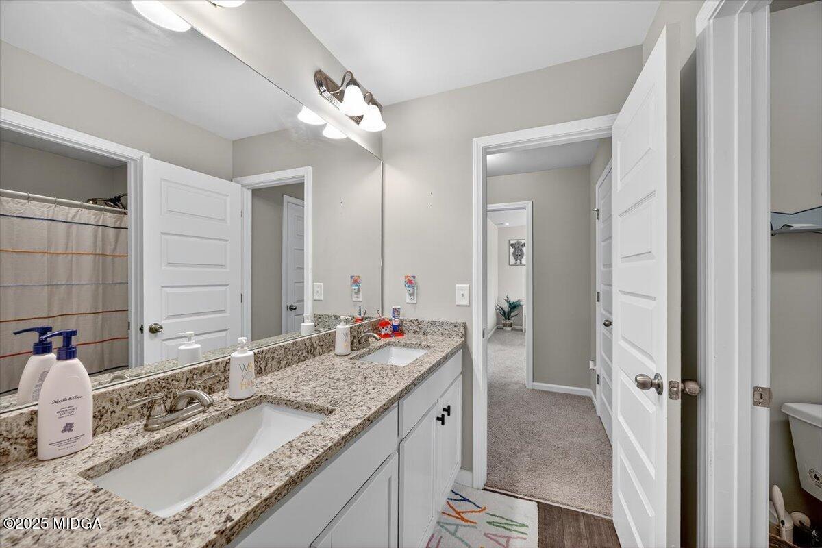 656 Dolly Drive Forsyth, GA 31029 - Photo 25 of 30 a bathroom with a granite countertop sink and a mirror