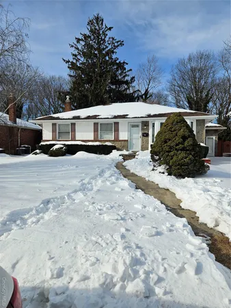 a view of a house with a yard covered in snow