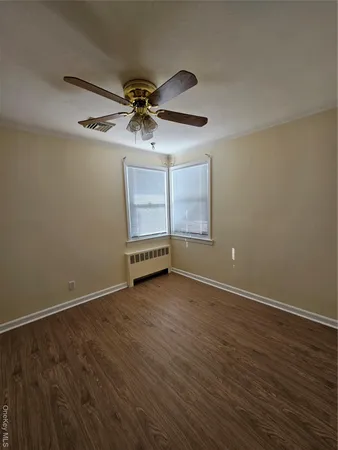 a view of a room with wooden floor closet and windows