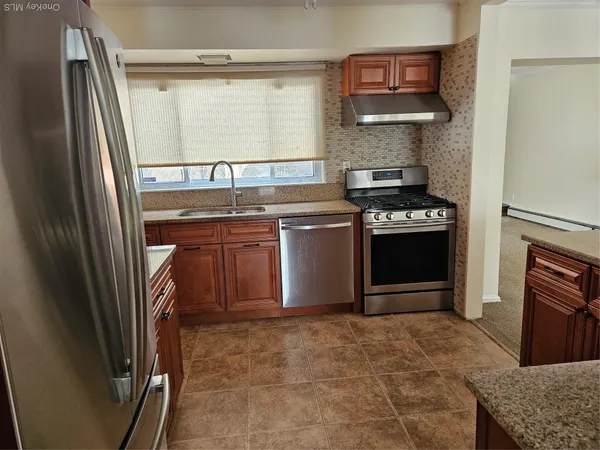 a kitchen with stainless steel appliances granite countertop a stove a refrigerator and a sink