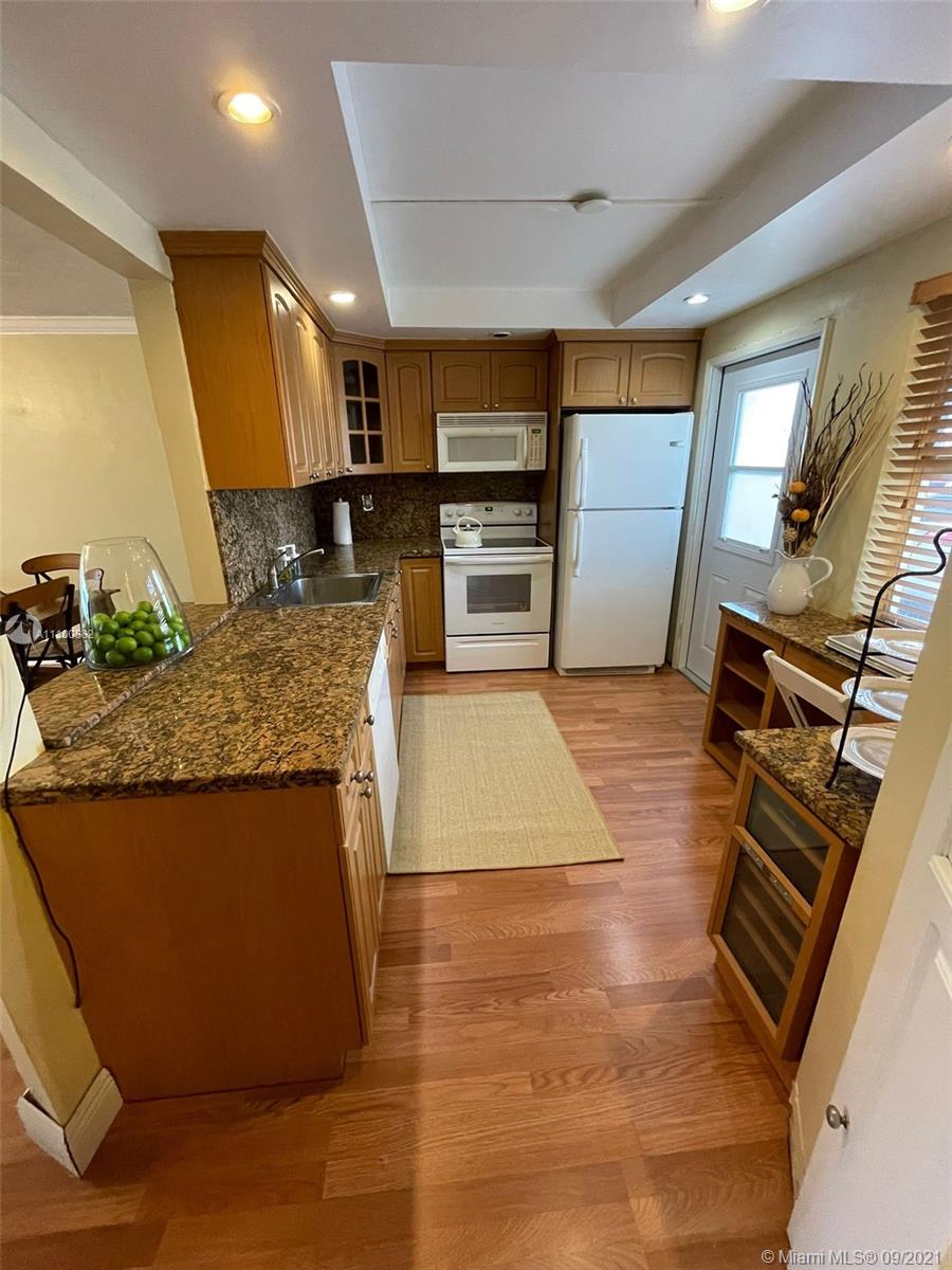 a large kitchen with kitchen island a stove a sink and a refrigerator