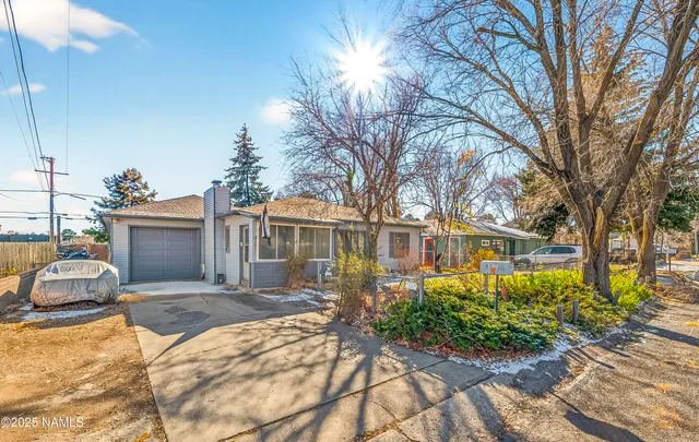 a front view of a house with a yard and potted plants