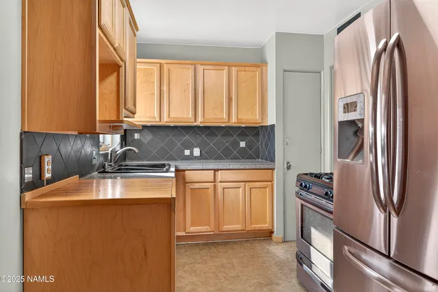 a kitchen with stainless steel appliances granite countertop a refrigerator and a sink