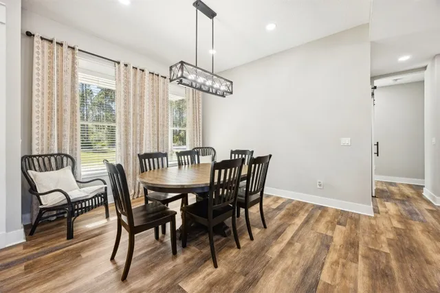 a dining room with furniture a chandelier and wooden floor