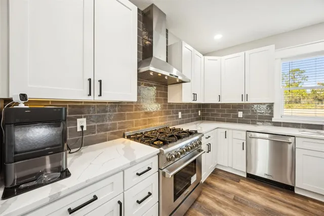 a large kitchen with kitchen island a sink appliances and wooden floor