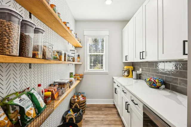a large kitchen with kitchen island a stove a sink a center island and wooden floor