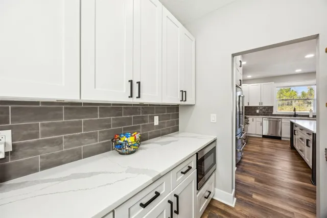 a kitchen with stainless steel appliances white cabinets and a window