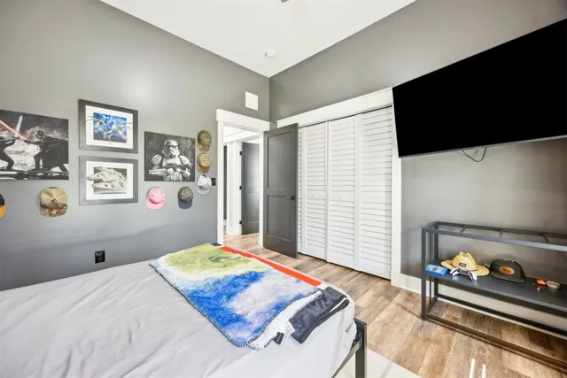 a bedroom with a bed table chair and window