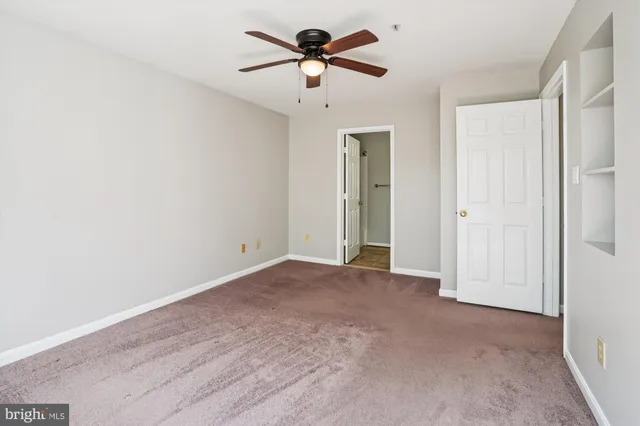a view of a livingroom with a ceiling fan and carpet