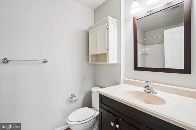 a bathroom with a sink vanity mirror and toilet