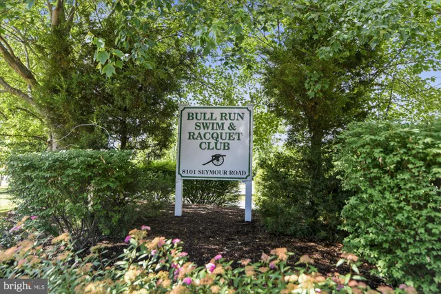 a sign that is sitting in front of a bunch of flowers