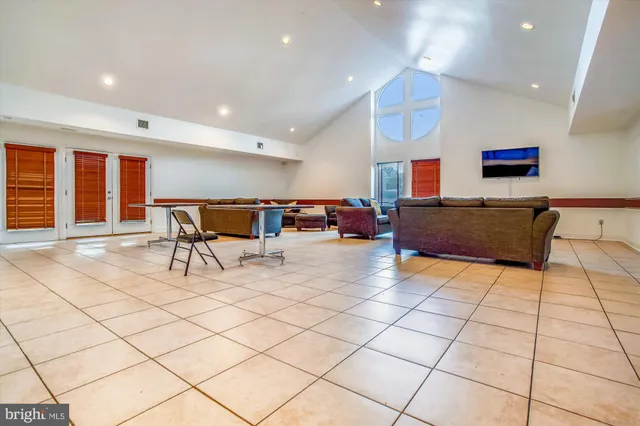 a living room with furniture and a dining table with projector the screen