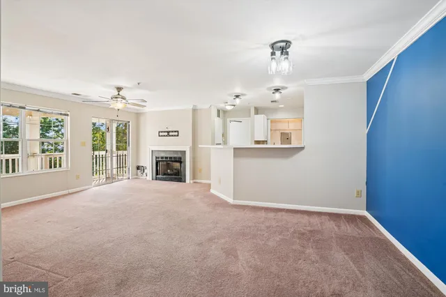 en empty room with windows and fireplace