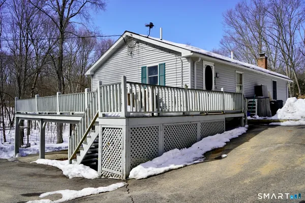 a view of a house with wooden deck front of house