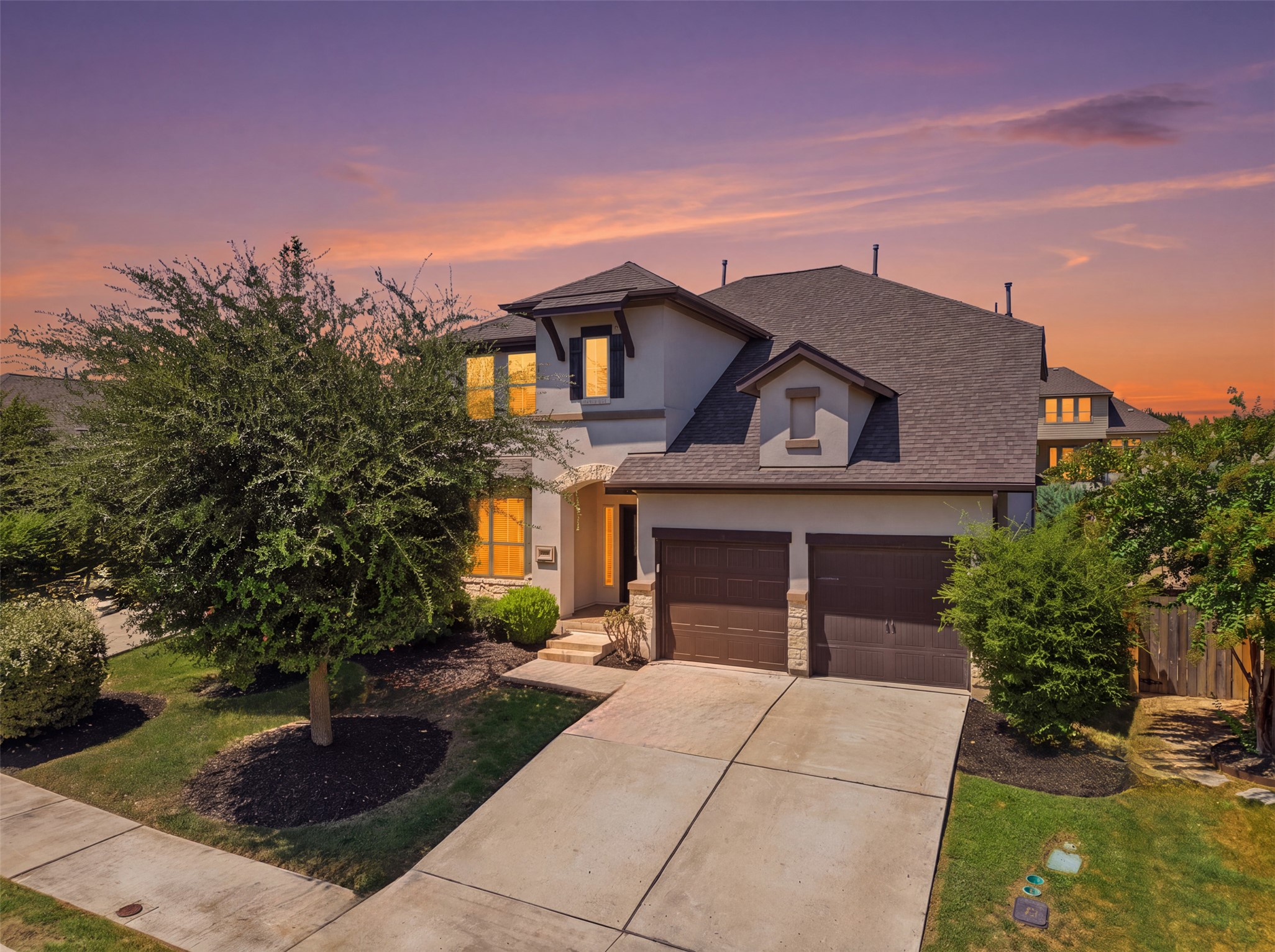 3101 Rabbit Creek Drive Georgetown, TX 78626 - Photo 1 of 38 An inviting exterior with a broad driveway and landscaped greenery welcomes you home under a vibrant sunset.