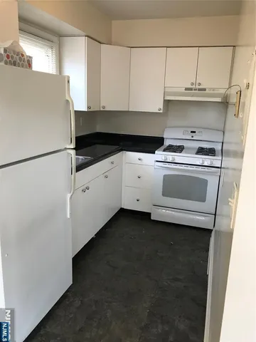 a kitchen with a refrigerator and a stove