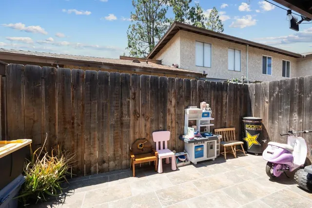 a backyard of a house with table and chairs