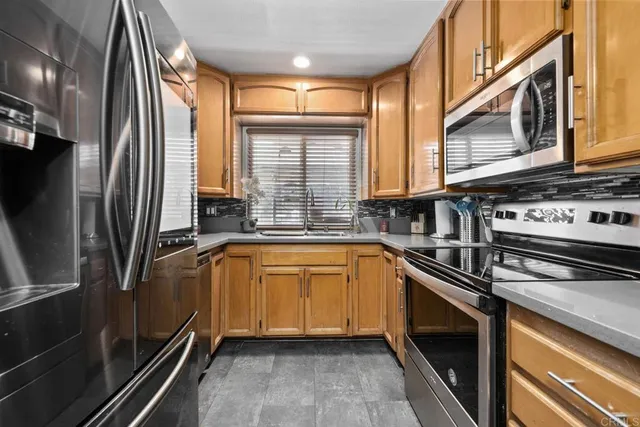 a kitchen with stainless steel appliances a sink stove and refrigerator