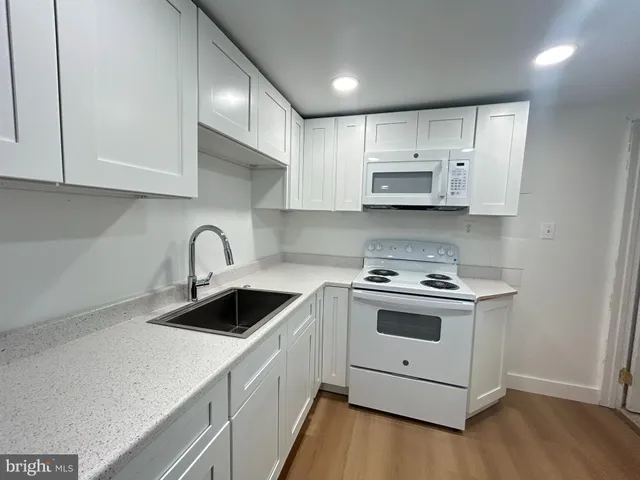 a kitchen with white cabinets stainless steel appliances and sink