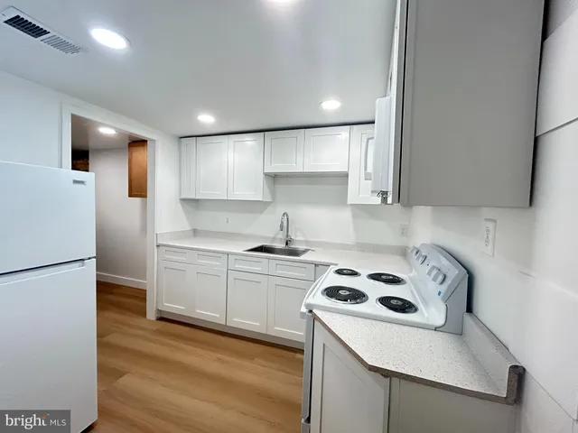 a kitchen with a white stove top oven and refrigerator