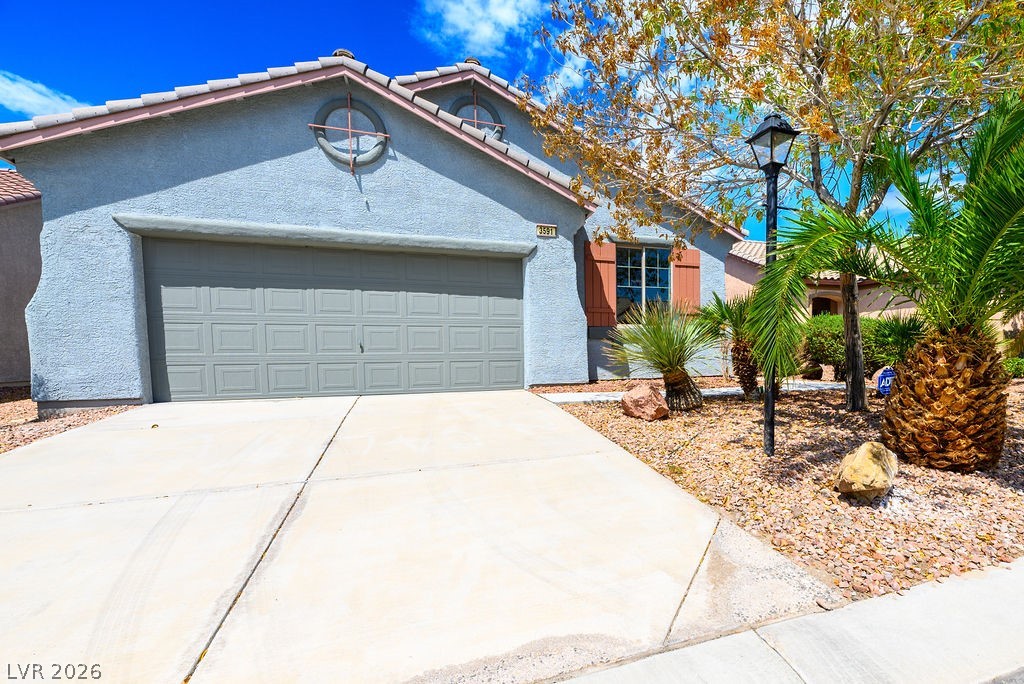 3591 Driving Range Street Las Vegas, NV 89122 - Photo 62 of 79 This charming home offers a spacious driveway and an inviting front exterior with attractive landscaping.