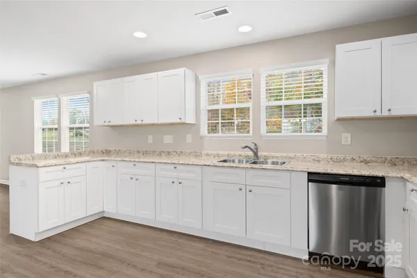 a kitchen with granite countertop cabinets sink and window