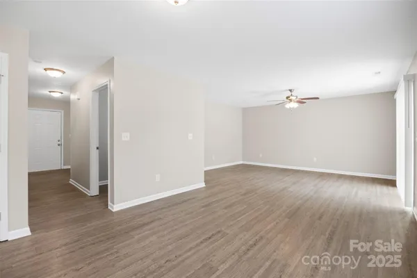 an empty room with wooden floor and mirror