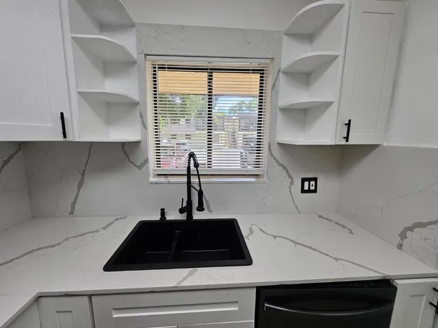 a kitchen with a sink a stove and a window
