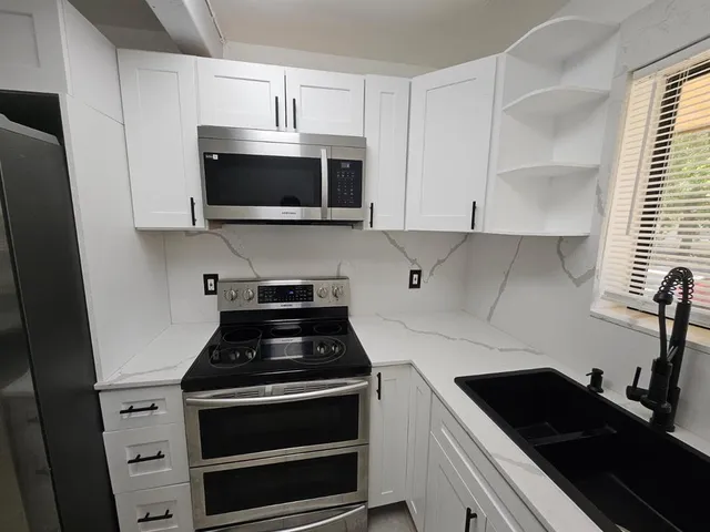 a kitchen with stainless steel appliances a stove a microwave and cabinets