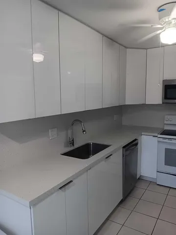 a kitchen with cabinets appliances a sink and a counter top