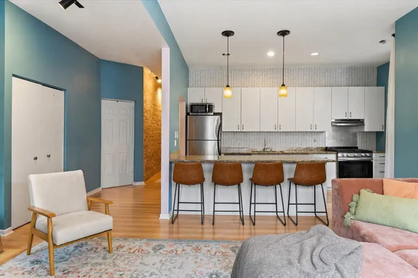 a kitchen with granite countertop a sink a center island and stainless steel appliances