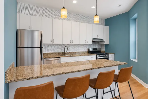 a kitchen with granite countertop a sink and white cabinets
