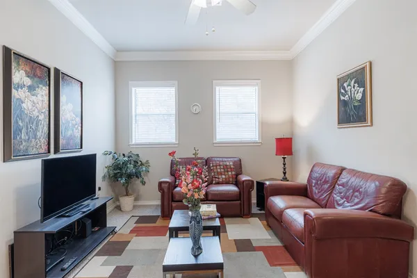 a living room with furniture a flat screen tv and a window