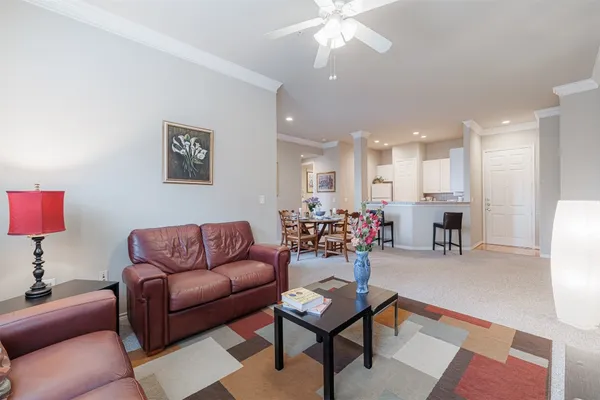 a living room with furniture and a dining table with kitchen view