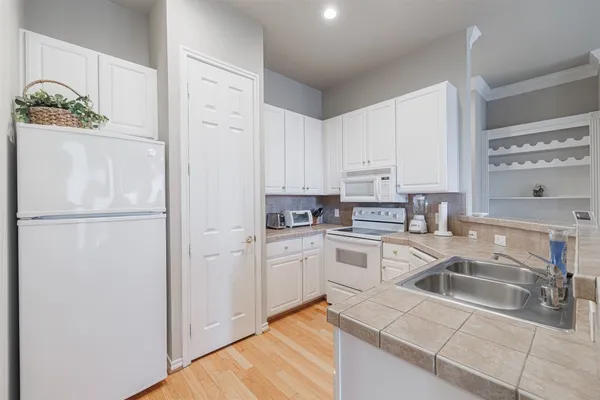a kitchen with white cabinets and white appliances