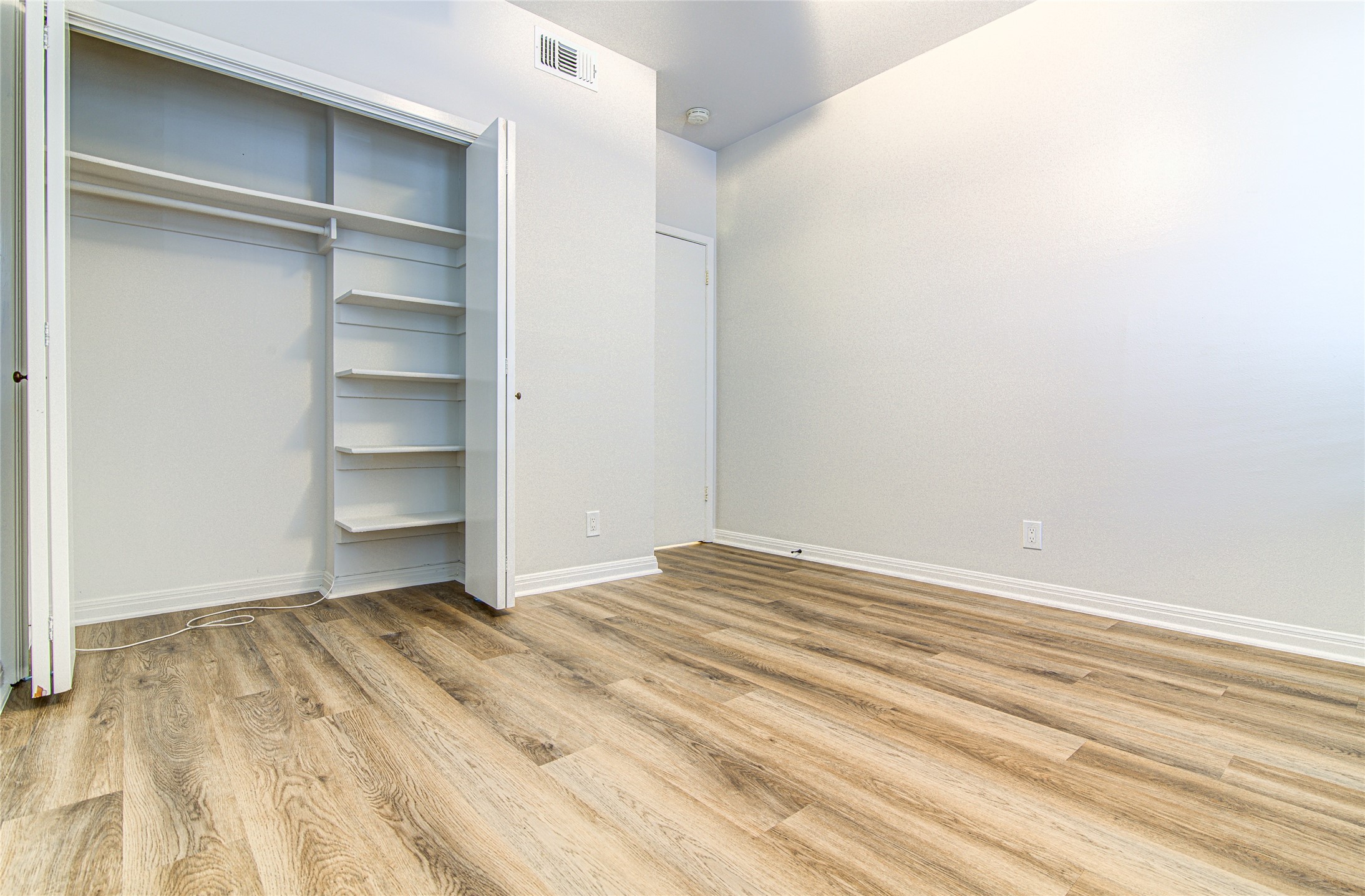 311 West Mary Street Austin, TX 78704 - Photo 29 of 35 Ample closet space with built-in shelving and hanging rod complements the wood-look flooring.