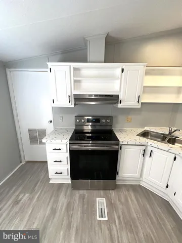 a kitchen with a stove and white cabinets
