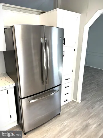 a view of kitchen with stainless steel appliances wooden floor
