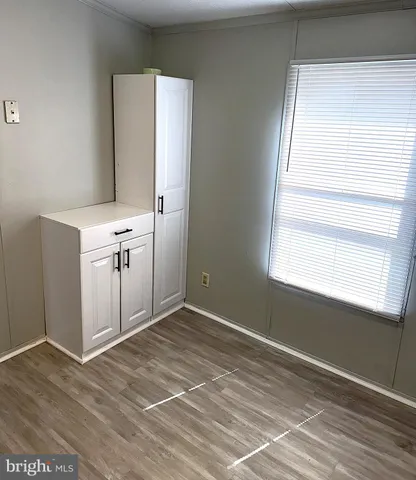 a view of empty room with window and wooden floor