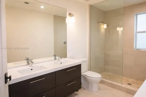 a bathroom with a double vanity sink toilet and shower