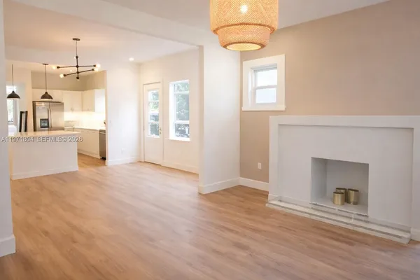 an empty room with windows and fireplace