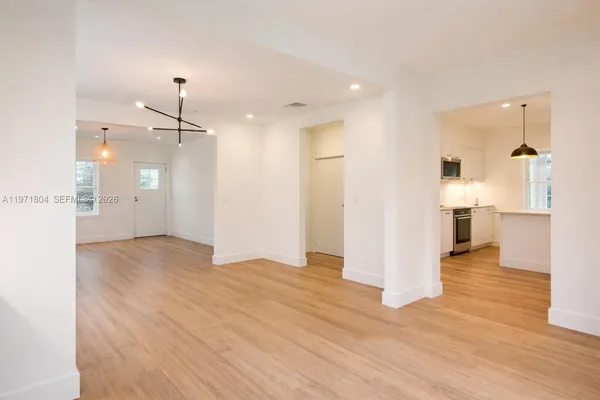 a view of a big room with wooden floor and a bathroom
