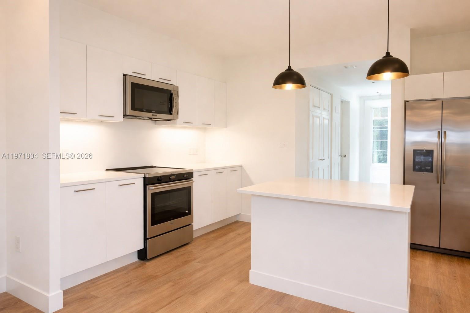 640 Northeast 71st Street Miami, FL 33138 - Photo 5 of 14 a kitchen with stainless steel appliances and wooden floor